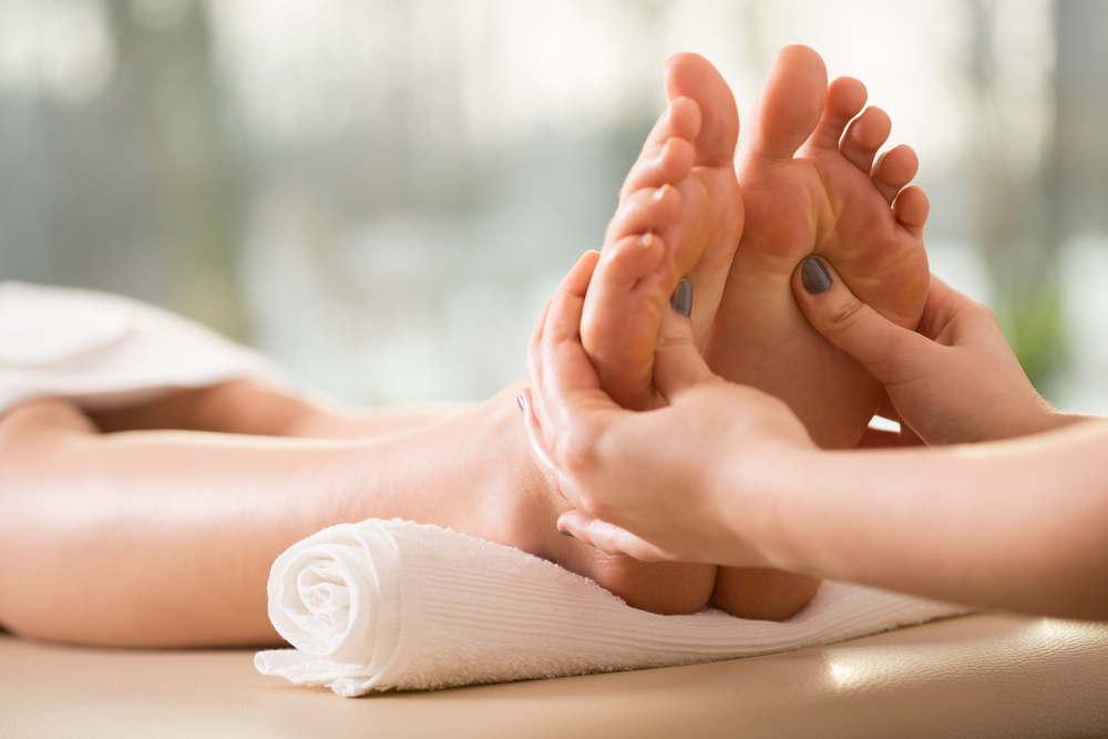 Spa de masaje de pies y cliente mujer lista para terapia de curación de pies  y tratamiento de relajación clínica de salud de fisioterapia y manos de  empleados trabajando y masajeando la